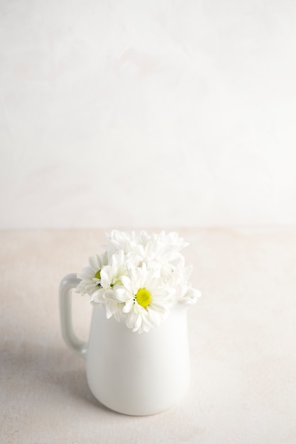 Photo gratuite marguerite de fleurs en pichet sur la table