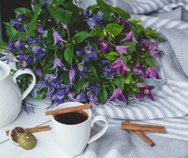 Marguerites, une tasse de thé et des bâtons de cannelle