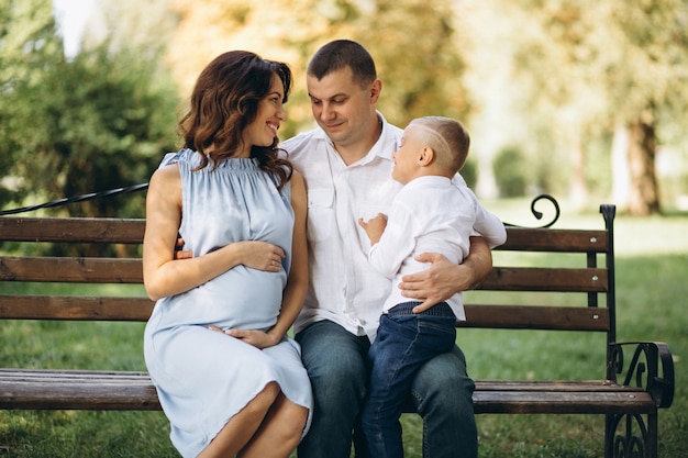 Photo gratuite mari avec femme enceinte et leur fils dans le parc