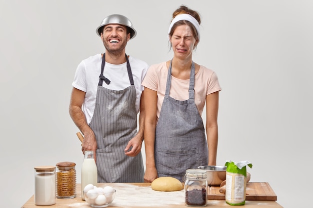 Mari et femme posent dans la cuisine en préparant un délicieux dîner