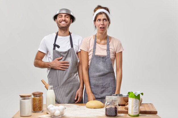 Mari et femme posent dans la cuisine en préparant un délicieux dîner