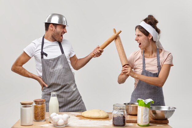 Mari et femme posent dans la cuisine en préparant un délicieux dîner