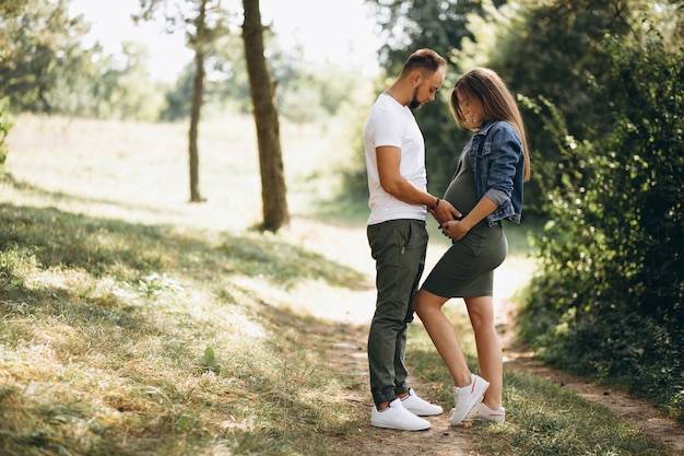 Mari avec sa femme enceinte marchant dans le parc