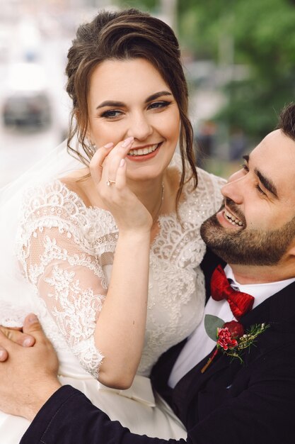 Marié sur un fauteuil roulant tient la mariée sur ses genoux assis dehors dans le parc