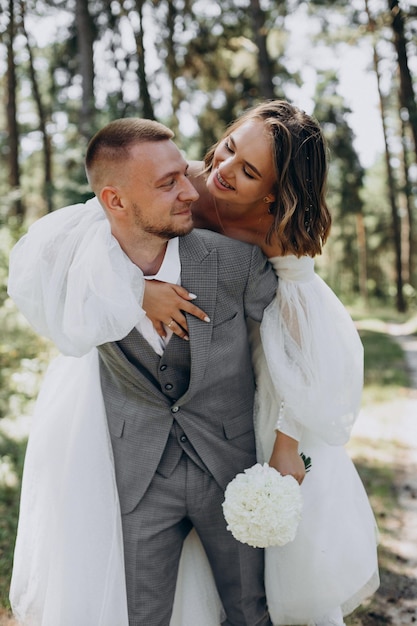 Photo gratuite le marié et la mariée le jour de leur mariage en forêt