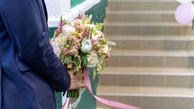 Un marié tenant un bouquet luxuriant, vue rapprochée, cérémonie de mariage