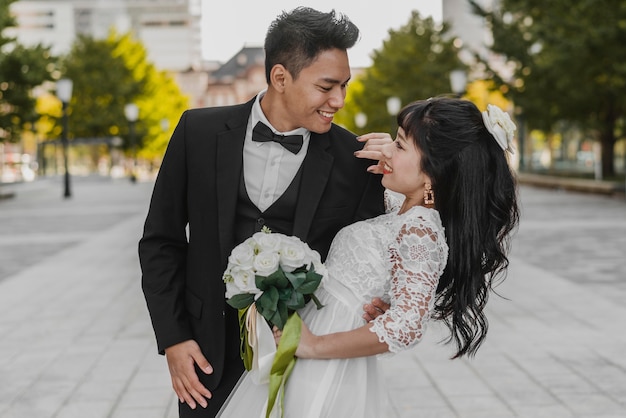 Photo gratuite marié tenant la mariée par son dos dans une pose romantique