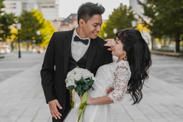 Marié tenant la mariée par son dos dans une pose romantique