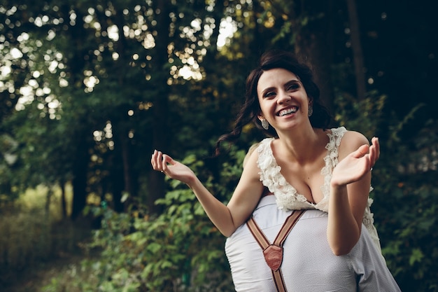 Le marié tient sa mariée dans ses bras quelque part dans la nature