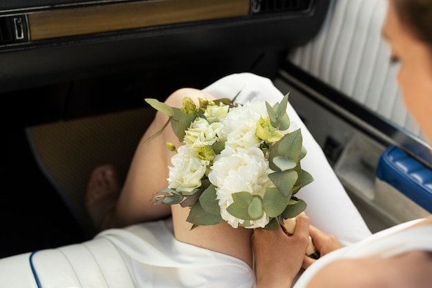 Photo gratuite mariée à angle élevé tenant des fleurs