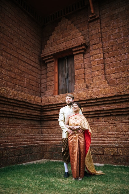 Photo gratuite mariée asiatique et marié caucasien ont du temps romantique avec la robe de la thaïlande