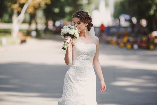 Mariée avec un bouquet dans le parc