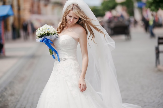 Mariée avec bouquet dans la rue