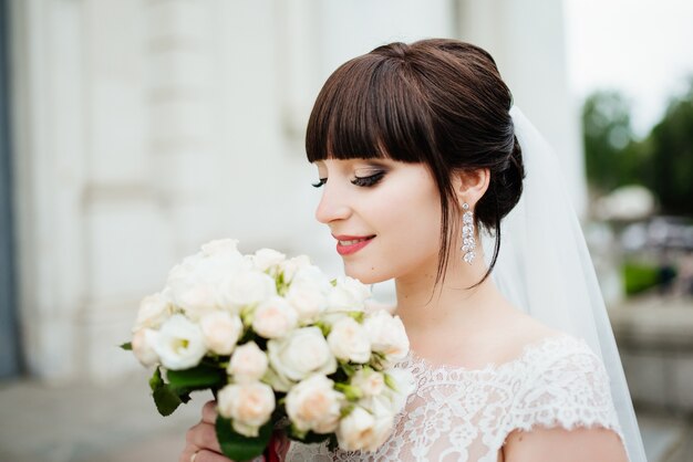 Mariée avec un bouquet, souriant. Portrait de mariage de la belle mariée. Mariage. Jour de mariage.