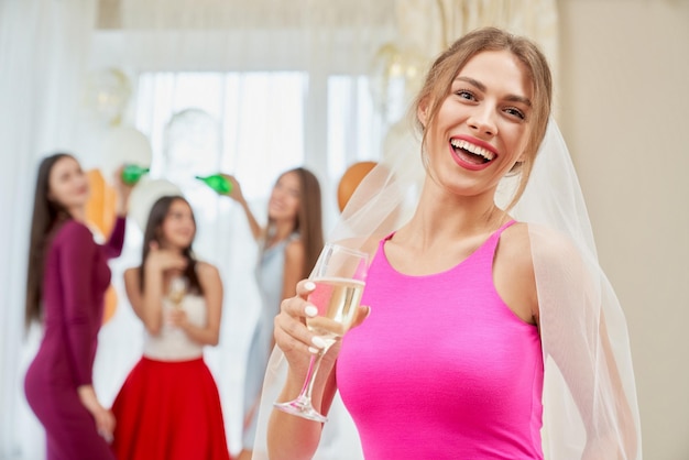 Mariée avec champagne riant à l'enterrement de vie de jeune fille