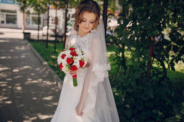 mariée décontractée posant avec son bouquet