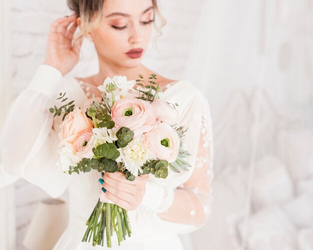 Mariée élégante posant avec son bouquet