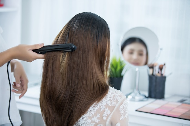 Mariée faire les cheveux avec la robe