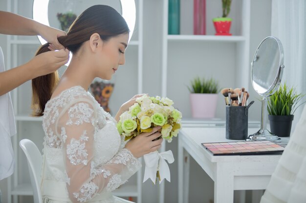 Mariée faire les cheveux avec la robe