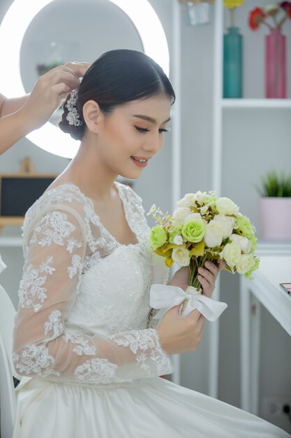 Mariée faire les cheveux avec la robe