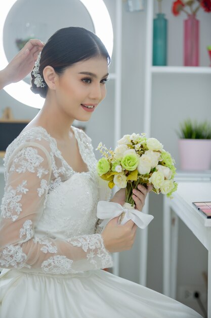 Mariée faire les cheveux avec la robe