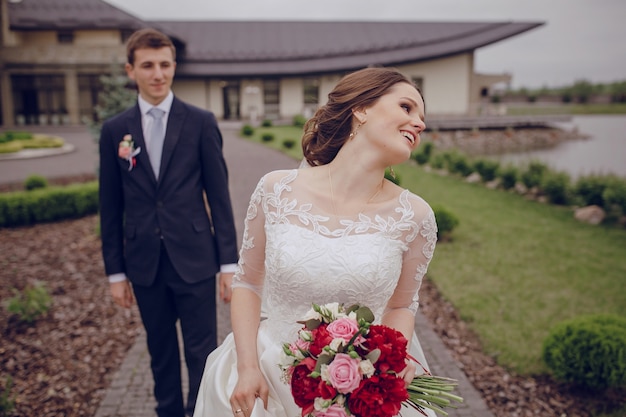 mariée heureux holding bouquet avec son mari derrière