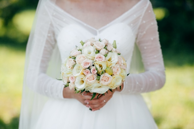 Mariée et marié avec un bouquet de fleurs rouges et de verts en main