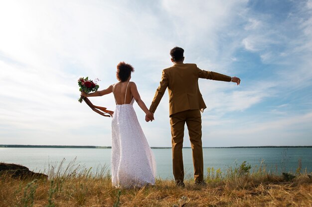 La mariée et le marié posent à l'extérieur.