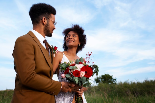 Photo gratuite la mariée et le marié posent à l'extérieur.