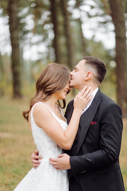 La mariée et le marié traversent une forêt Séance photo de mariage