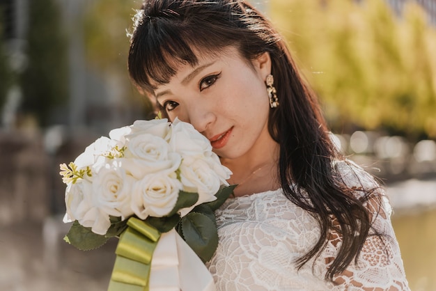 Photo gratuite mariée posant avec beau bouquet de fleurs