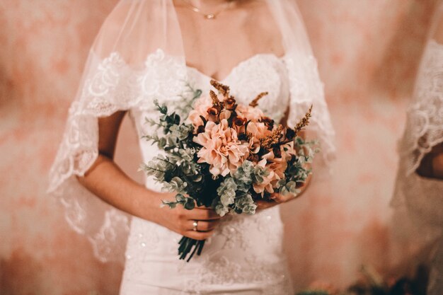 Mariée tenant le beau bouquet de mariage