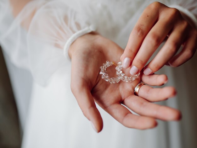 Mariée, tenue, boucles d'oreilles, sur, elle, mains