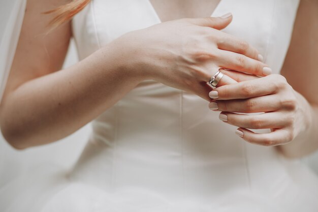 La mariée touche son doigt avec une alliance