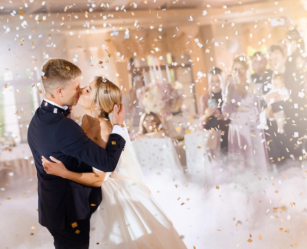 Les mariées s'embrassent et s'étreignent en tombant des confettis