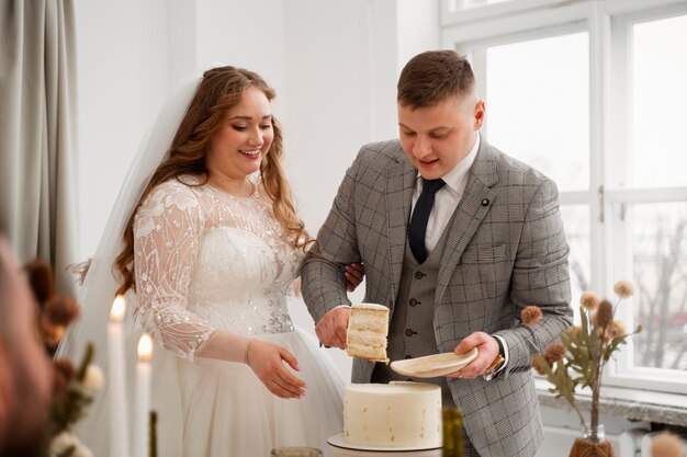 Les mariés coupent le gâteau à leur mariage