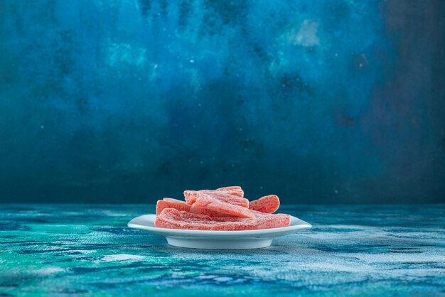 Marmelade rouge dans une assiette sur la surface bleue