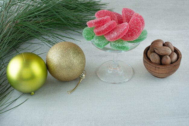 Marmelade de sucre vert et rouge avec des boules de Noël sur fond blanc. Photo de haute qualité