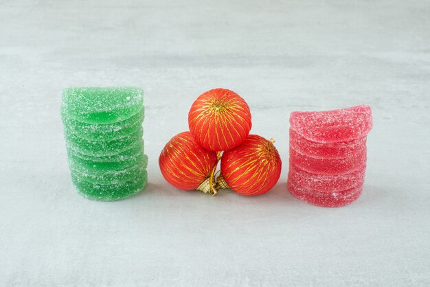 Marmelade de sucre vert et rouge avec des boules de Noël rouges sur fond de marbre. Photo de haute qualité