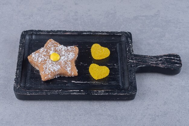 Marmelades de coeur et cookie étoile sur un plateau sur une surface en marbre