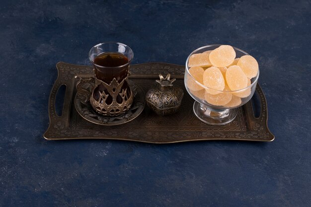 Marmelades avec un verre de thé dans un plateau métallique