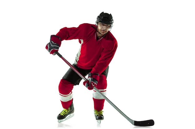 Photo gratuite marquer un but. joueur de hockey masculin avec le bâton sur un court de glace et un mur blanc. sportif portant de l'équipement et un casque pratiquant. concept de sport, mode de vie sain, mouvement, mouvement, action.