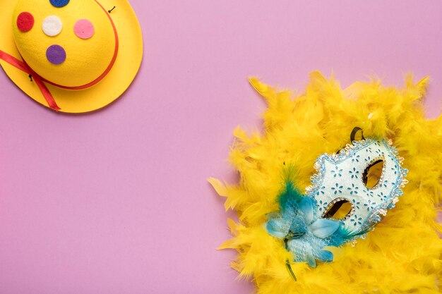 Photo gratuite masque de carnaval bleu avec boa de plumes jaunes sur fond rose