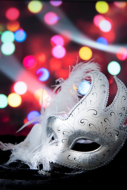 Photo gratuite masque de carnaval devant des lumières brouillées