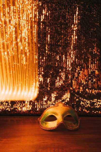 Masque de carnaval doré vénitien avec un beau fond de paillettes dorées