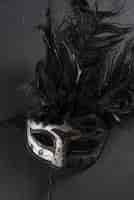 Photo gratuite masque de carnaval gris avec plume sur table