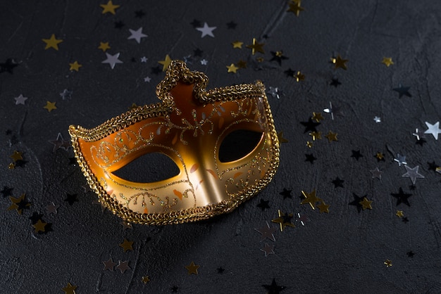 Photo gratuite masque de carnaval à paillettes sur tableau noir