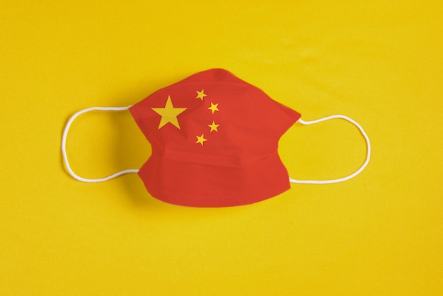 Masque chirurgical sur fond jaune avec le drapeau de la Chine