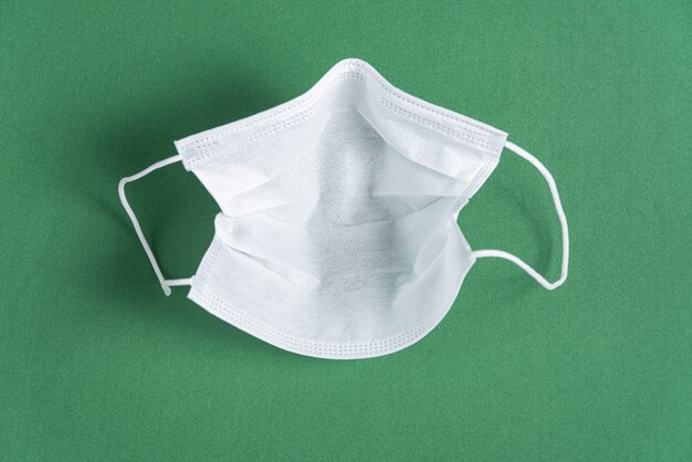 Masque chirurgical sur fond vert minimaliste