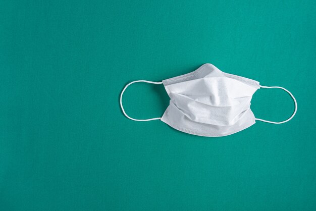 Masque chirurgical sur fond vert minimaliste